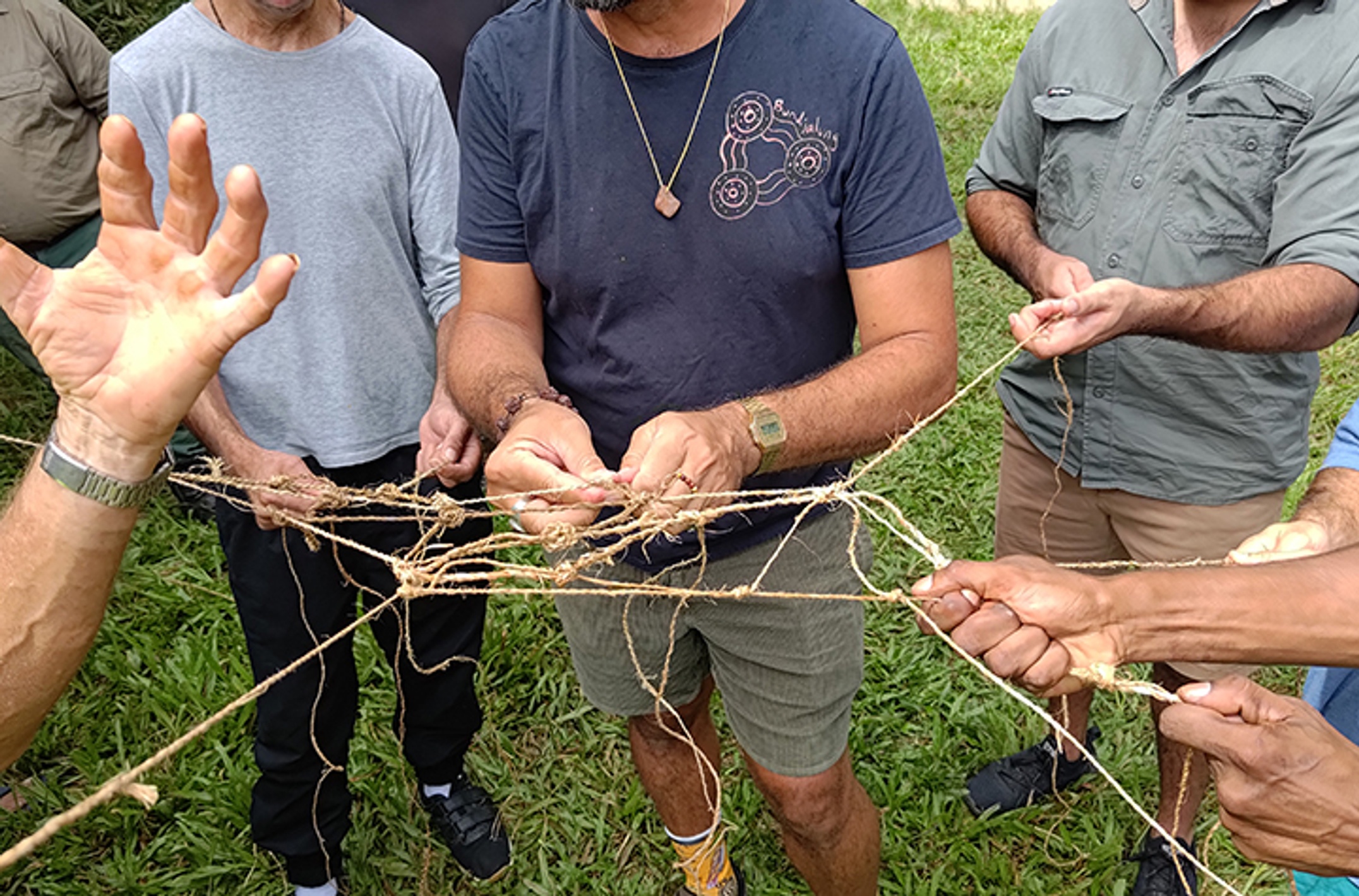 Men making a fishing net from plant fibres