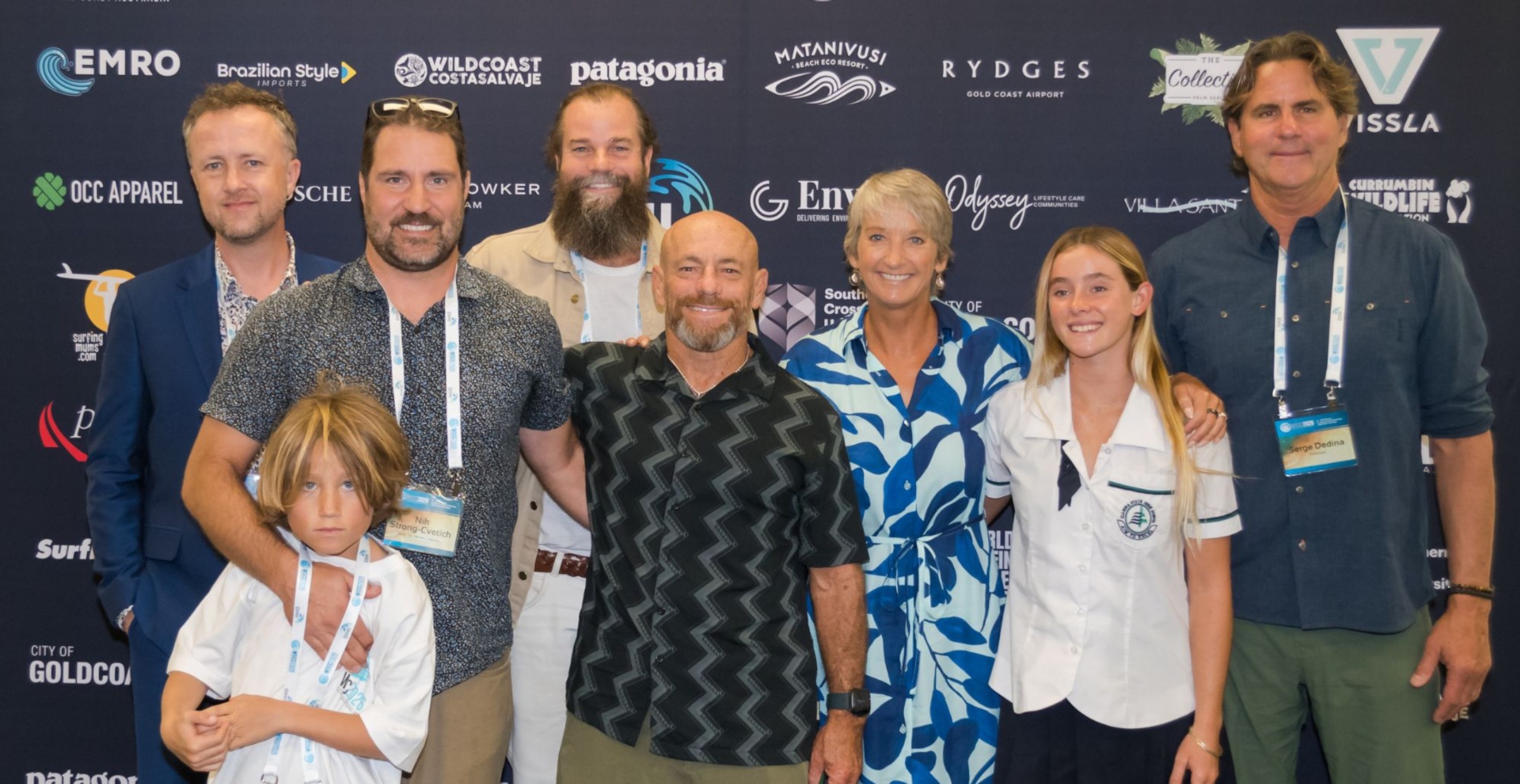 Group of people looking at the camera with media backdrop behind