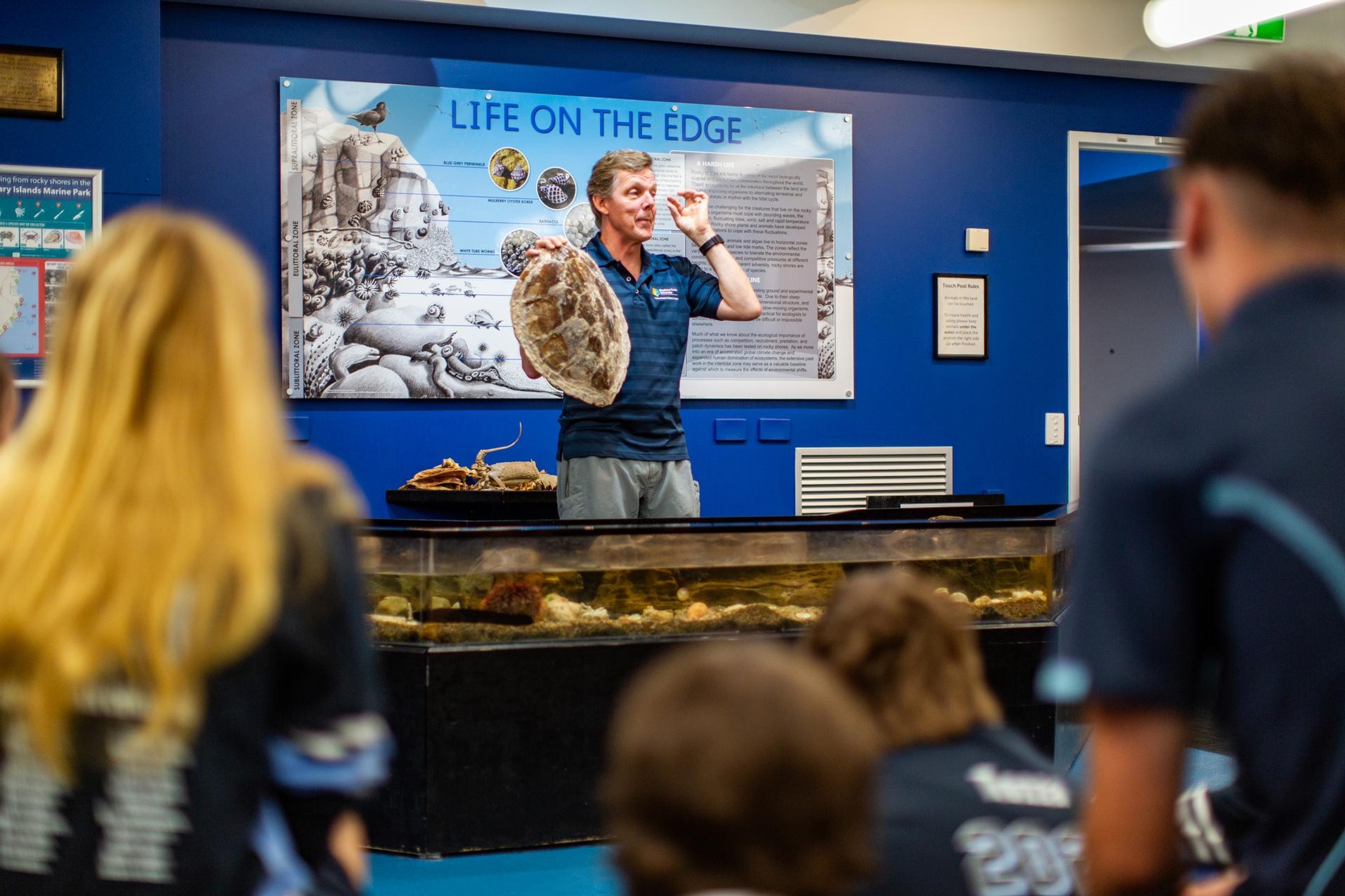 Stephan Soule holding turtle in classroom with students