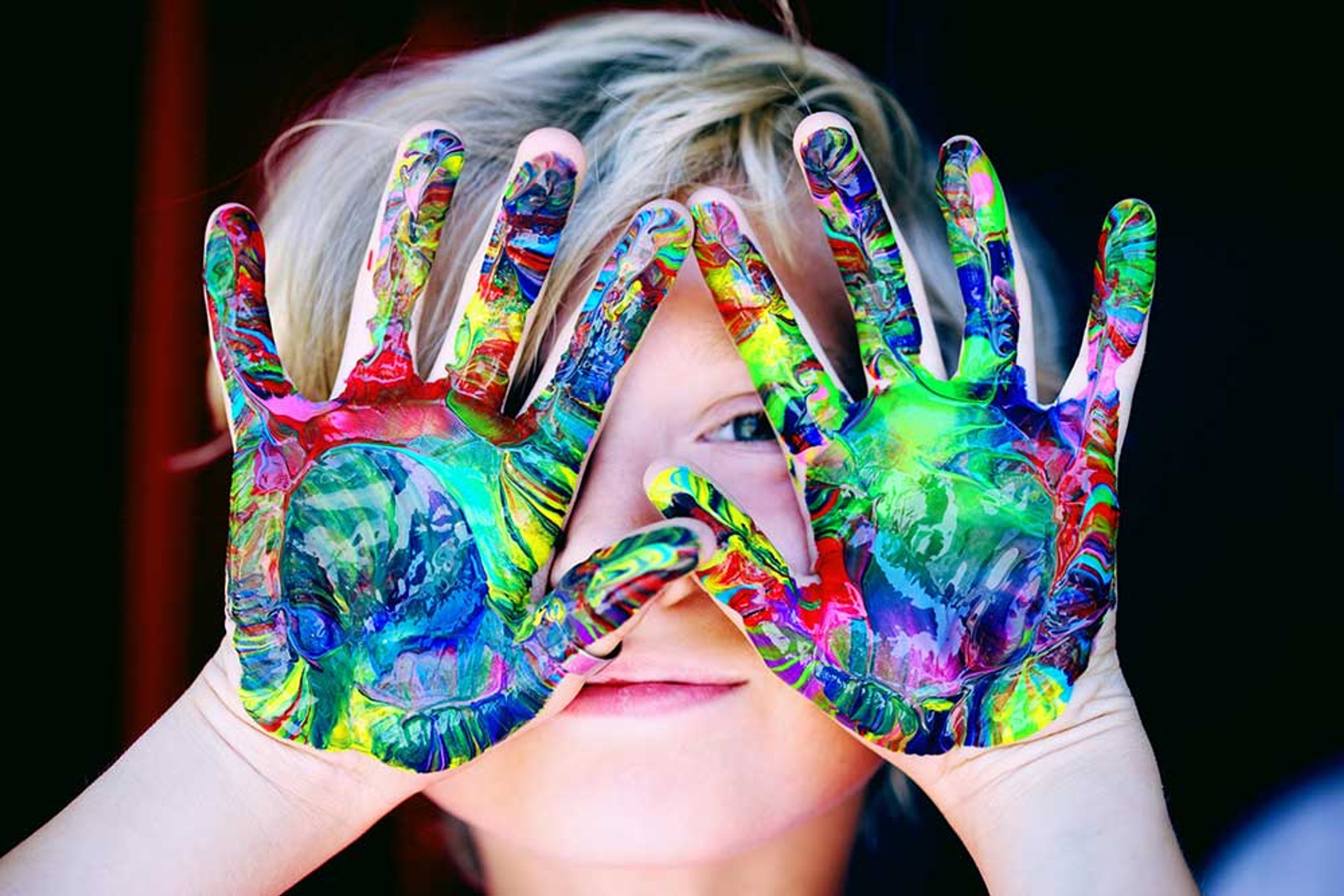 Boy smiling at camera with painted hands