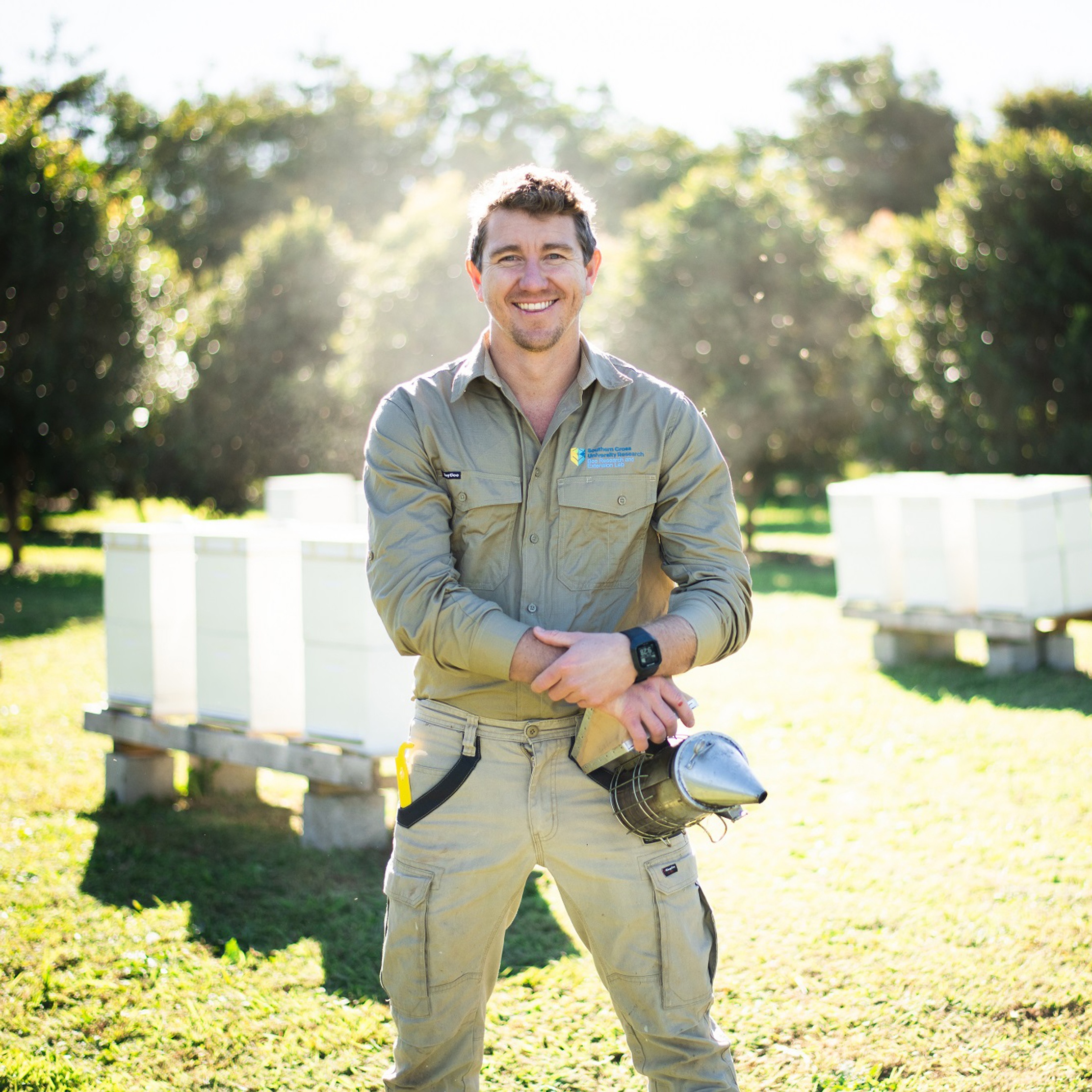 A man in a field with bee hives