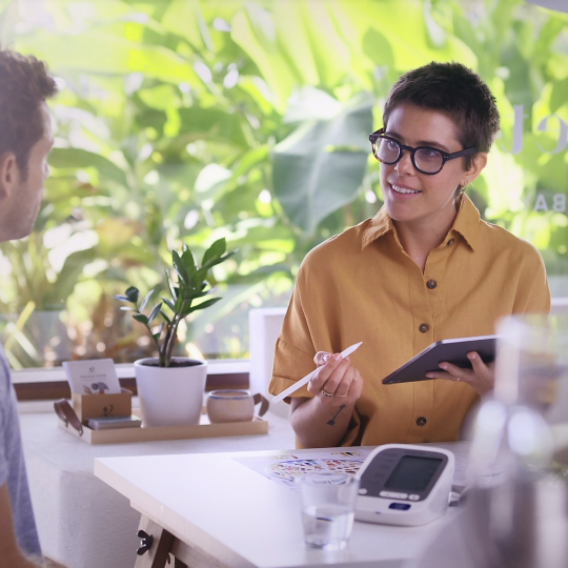 A female therapist sitting at a desk with a male client