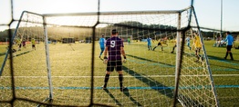 A man stands in front of a soccer goal