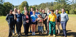 A group of people on a sports oval looking at the camera