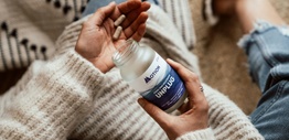 A woman's hands holding a bottle containing health supplements