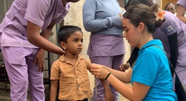 A nursing student measuring a boy's arm