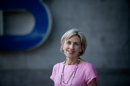 A woman in a pink dress smiling at the camera