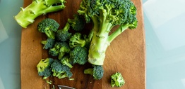 Broccoli on chopping board with a knife