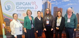 A group of people standing in front of a banner