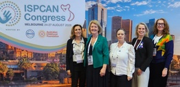 A group of women standing in front of a banner
