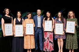 Vice Chancellor standing with students holding certificates