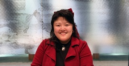 Woman in red jacket smiling at camera