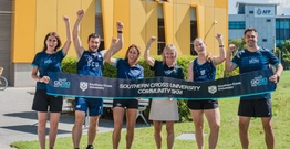 A group of people hold a banner advertising the GC50 Run Festival