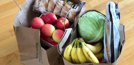 Paper bags with groceries including fruits and vegetables and bread