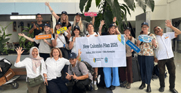 Group of Australian students at airport holding banner with Indonesian