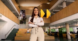 Student standing with arms crossed. Fast forward button is beyond them.