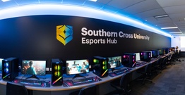 Computers with southern cross branding on black wall above