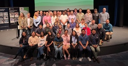 Large group of people smiling on a stage