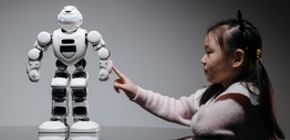 A young girl engaging with a robotic toy, highlighting curiosity and innovation
