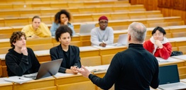 A lecturer standing in front of students in a university lecture room