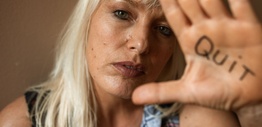 Blonde-haired woman with Quit written on her hand