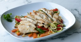 Sliced chicken breast on plate of mixed vegetables