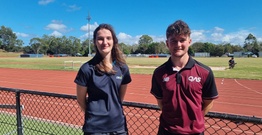 A woman and man standing in front of running track