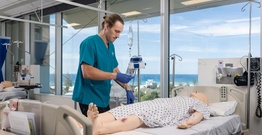 Student working on nursing sim doll