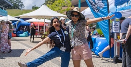 Two people hugging excitedly and smiling at camera