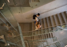 A male and female student walking up stairs. Photo taken from above.