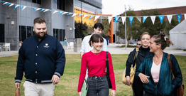Students walking in grassy field at Gold Coast campus