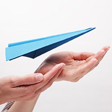 hands giving lift-off to a blue paper plan