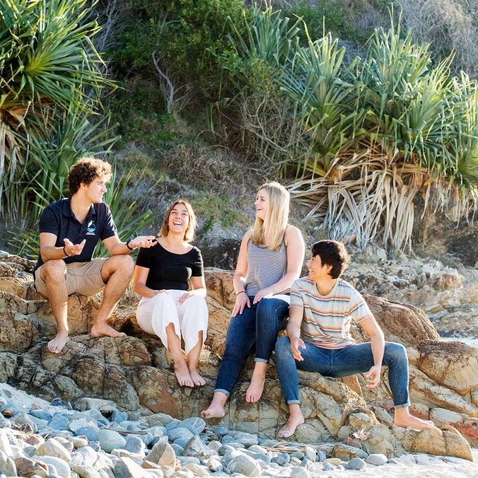 International students sitting on beach