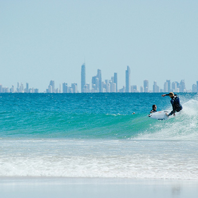 Mick-Fanning-surfing-on-Coolangatta-beach-with-city-skyline