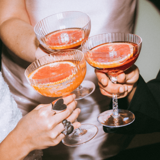 Hands holding cocktails in a circle