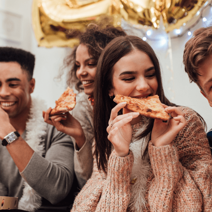 People smiling and eating pizza