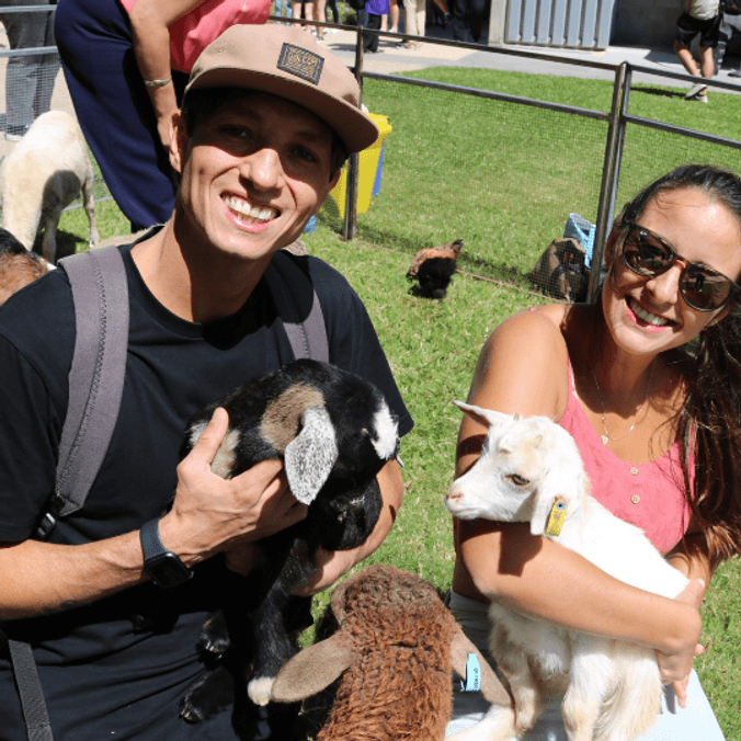 2 students holding baby farm animals