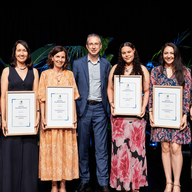 Vice Chancellor standing with students holding certificates