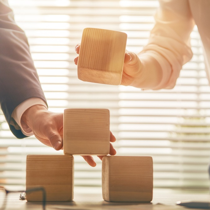 hands placing blocks on table