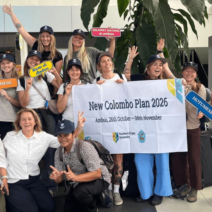 Group of Australian students at airport holding banner with Indonesian