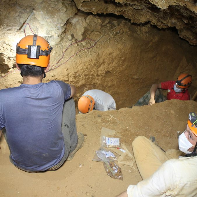 A group of scientists sit in a cave