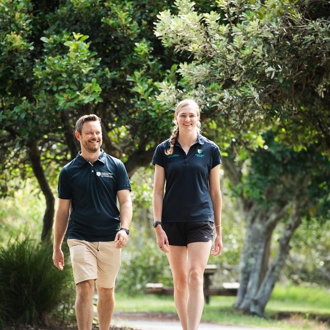 Two people walking through a park
