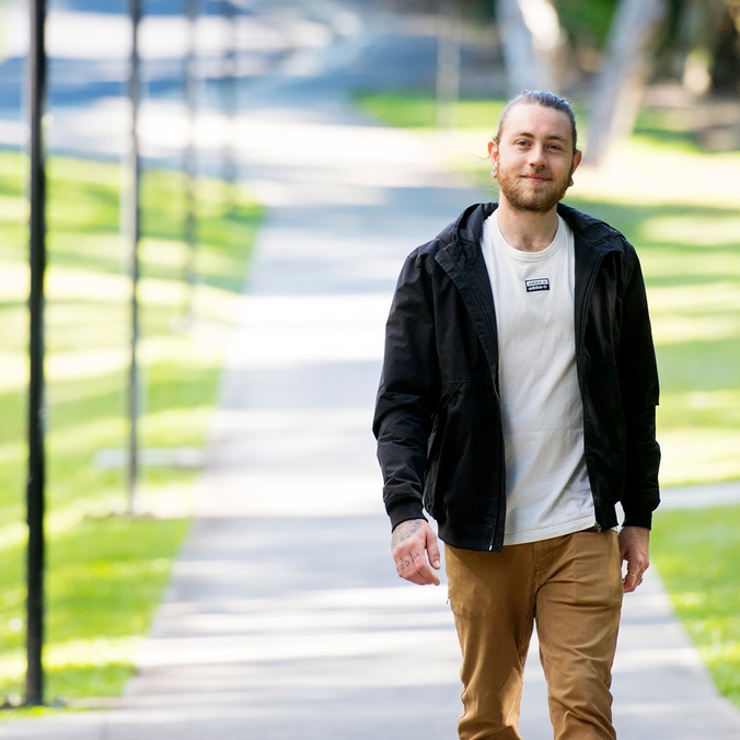 Male student walking on path
