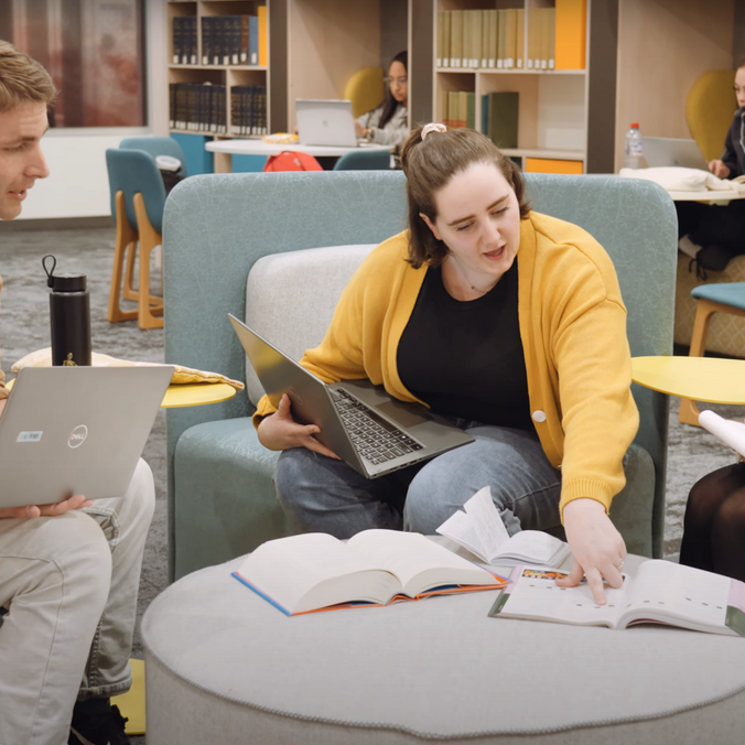 Students sitting in library talking about innovation.