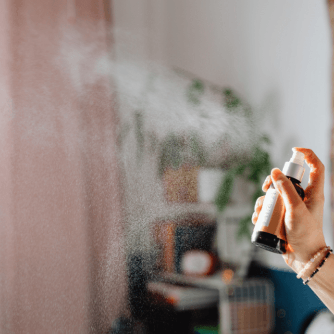 A person spraying spray into a room