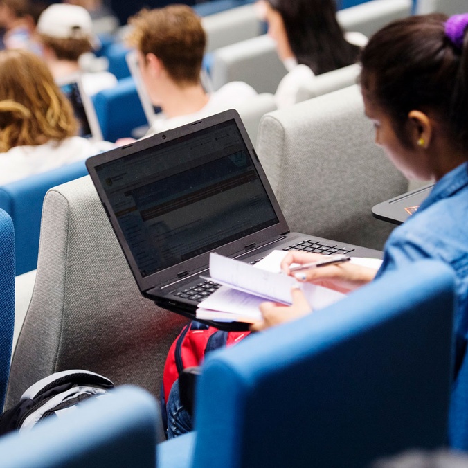 Student in auditorium with laptop