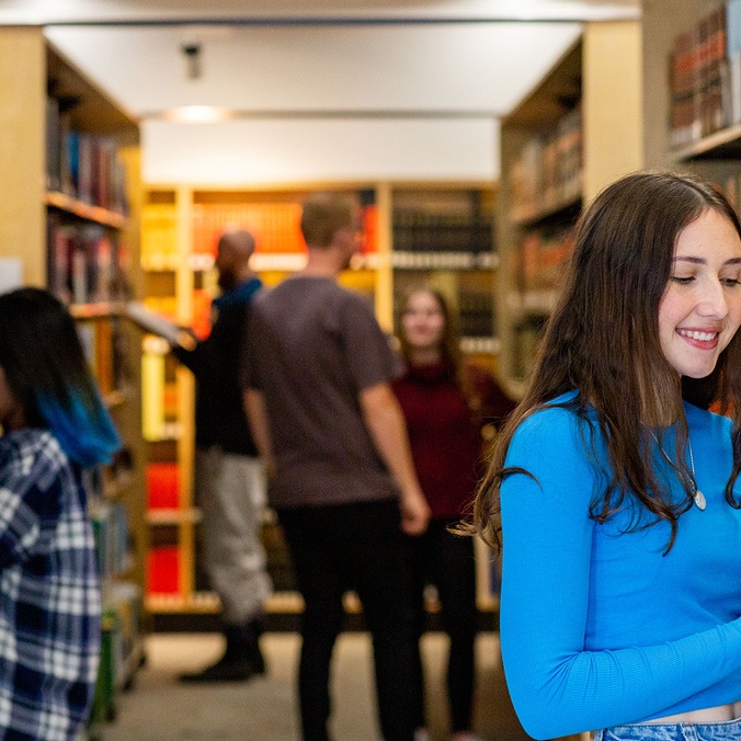 Student reading at book in a library