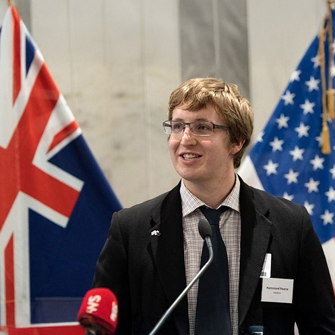 Head and shoulder of man standing in front of flags