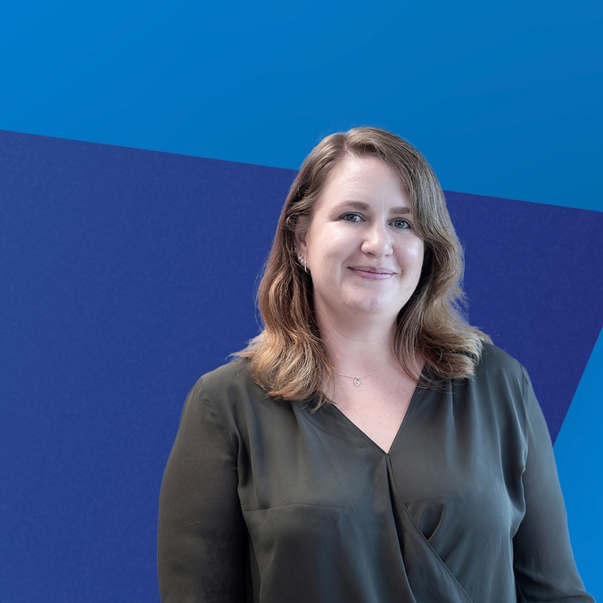 Female student in front of a blue banner
