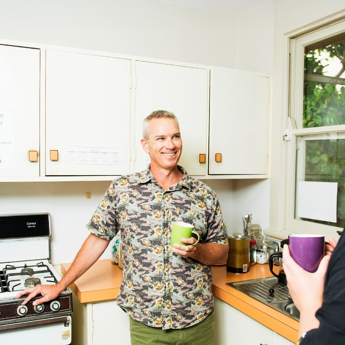 Man in kitchen talking to a woman